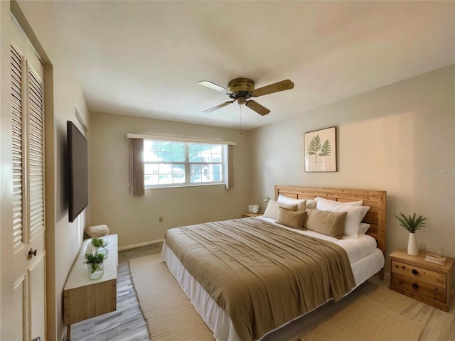 bedroom with ceiling fan, a closet, and light hardwood / wood-style flooring