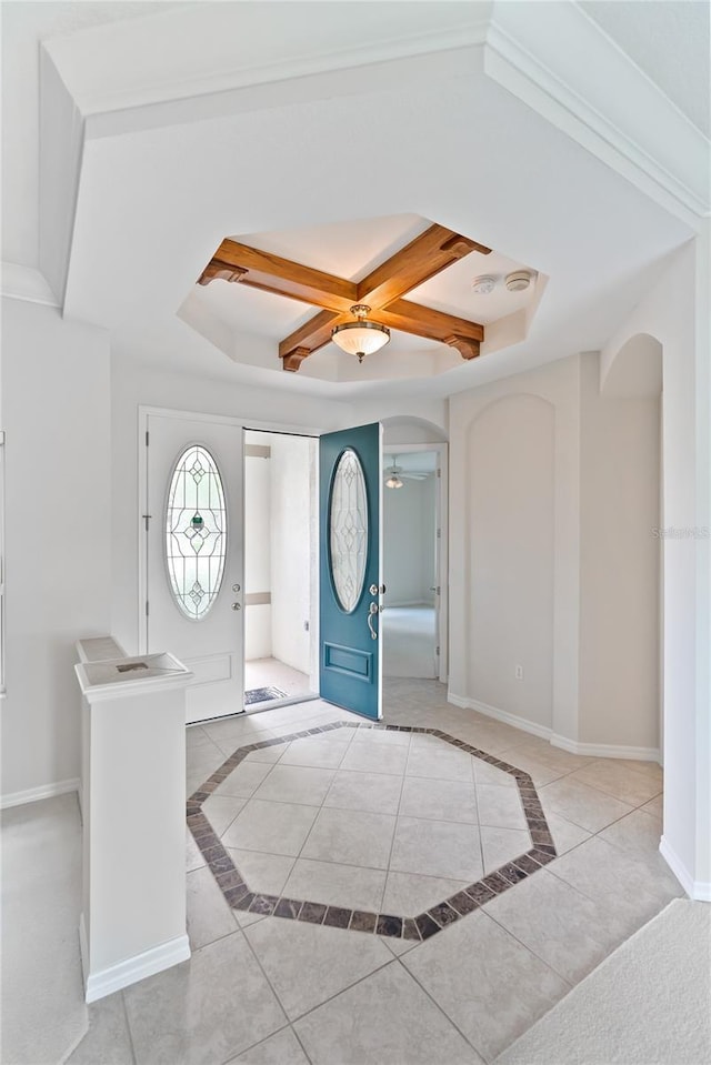 entrance foyer with light tile patterned floors, a tray ceiling, ceiling fan, and coffered ceiling