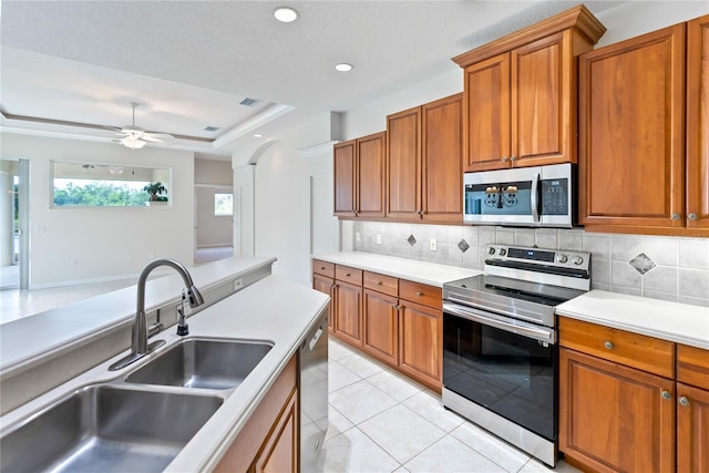 kitchen featuring tasteful backsplash, ceiling fan, sink, and stainless steel appliances