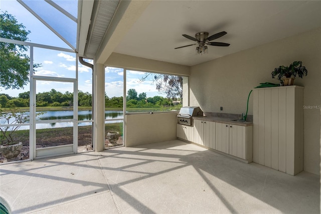 unfurnished sunroom with ceiling fan and a water view