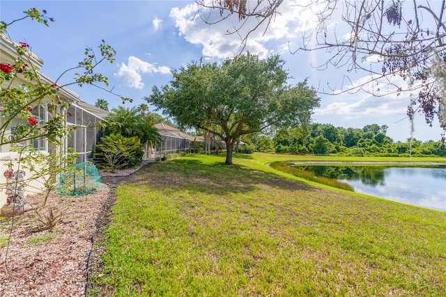 view of yard featuring a lanai and a water view