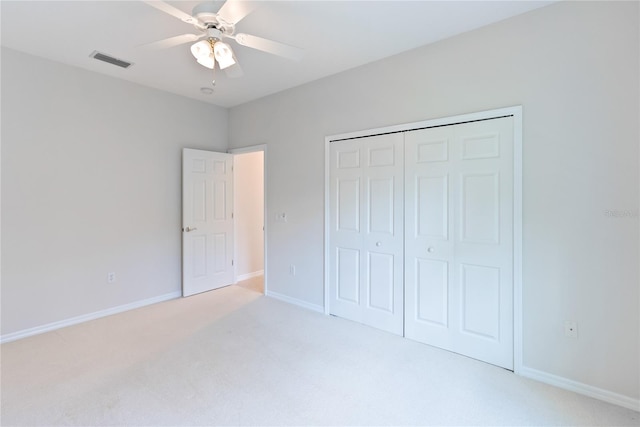 unfurnished bedroom with a closet, light colored carpet, and ceiling fan