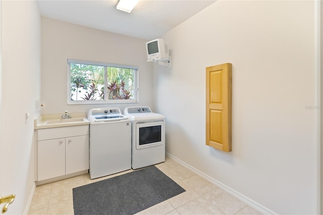 laundry room featuring sink, light tile patterned flooring, cabinets, and independent washer and dryer