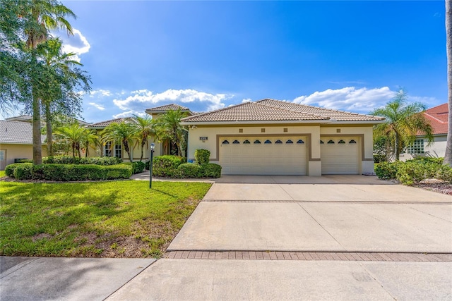 mediterranean / spanish-style home featuring a garage and a front yard