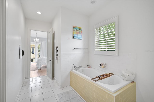 bathroom featuring tile patterned flooring, a relaxing tiled tub, and a notable chandelier