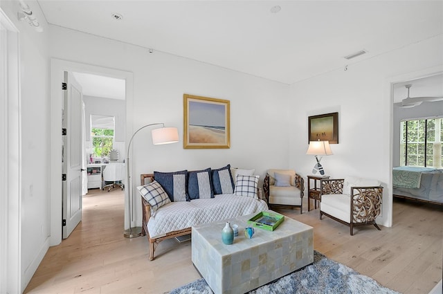 living room with ceiling fan and light hardwood / wood-style floors