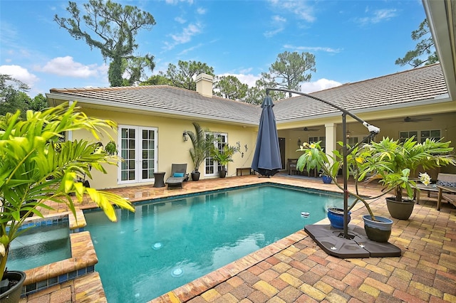 view of swimming pool featuring ceiling fan, an in ground hot tub, a patio, and french doors