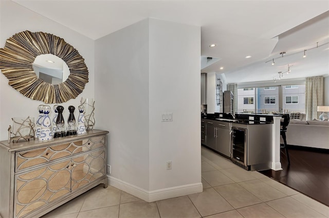 kitchen featuring sink, light tile patterned flooring, and beverage cooler