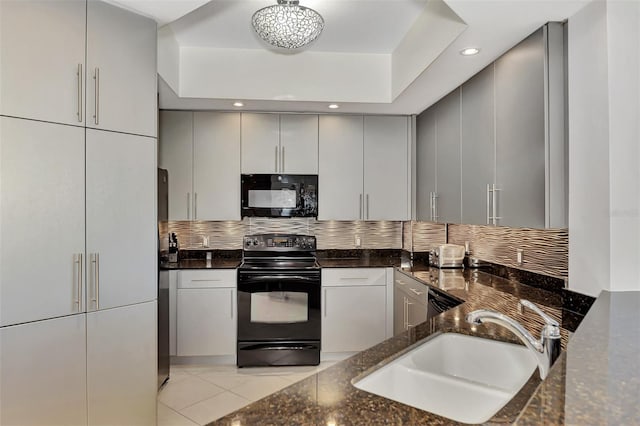 kitchen with backsplash, dark stone counters, black appliances, sink, and light tile patterned flooring