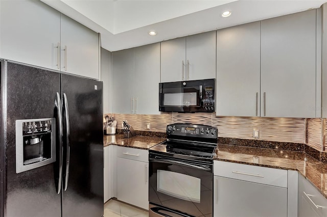 kitchen with dark stone counters, decorative backsplash, light tile patterned floors, and black appliances