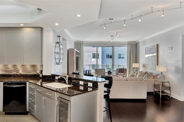 kitchen with hardwood / wood-style floors, dishwasher, dark stone counters, sink, and wine cooler