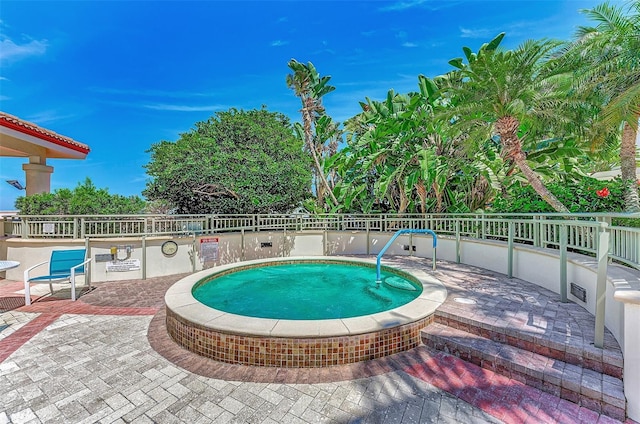 view of swimming pool with a hot tub