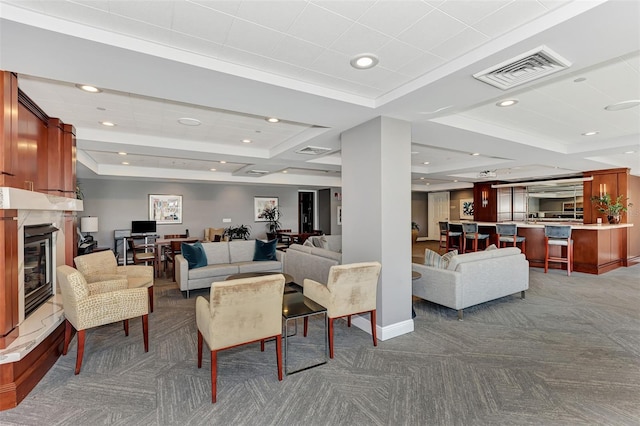 living room with dark colored carpet and a raised ceiling