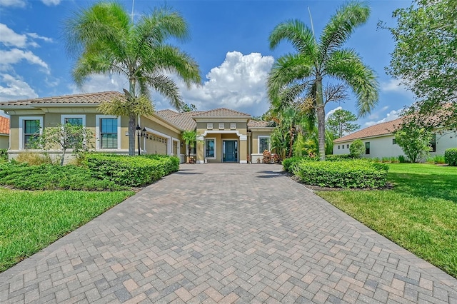 mediterranean / spanish-style home featuring a front yard and a garage