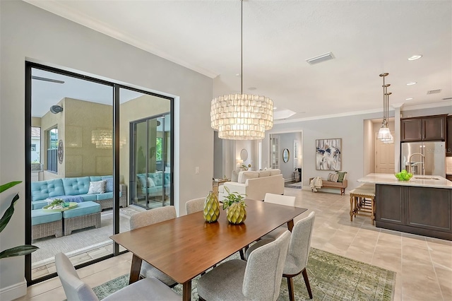 tiled dining area featuring a chandelier, crown molding, and sink