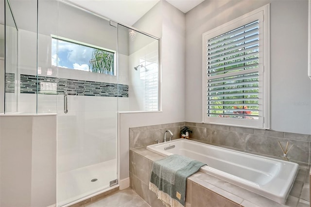 bathroom with plus walk in shower, tile patterned floors, and plenty of natural light