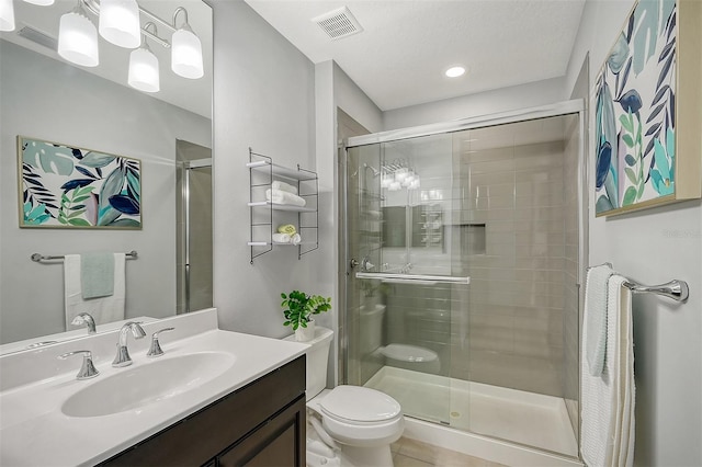 bathroom featuring vanity, toilet, and a shower with door