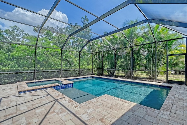 view of pool with glass enclosure, an in ground hot tub, and a patio