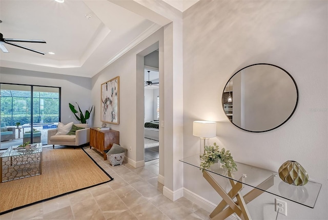 hallway featuring a tray ceiling and crown molding