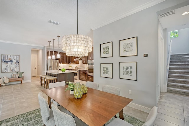 dining space featuring light tile patterned floors, ornamental molding, a textured ceiling, and a notable chandelier