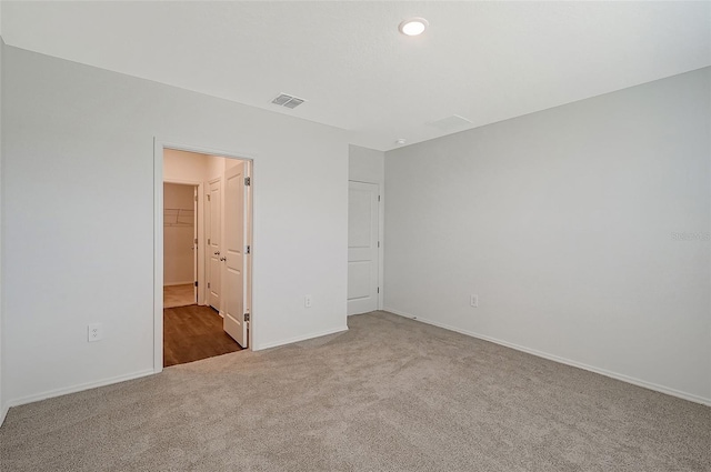 unfurnished bedroom with carpet floors, a spacious closet, and a closet