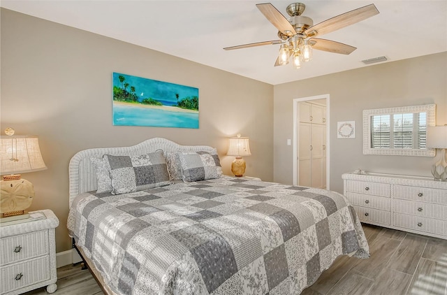 bedroom with light wood-type flooring, ceiling fan, and a closet