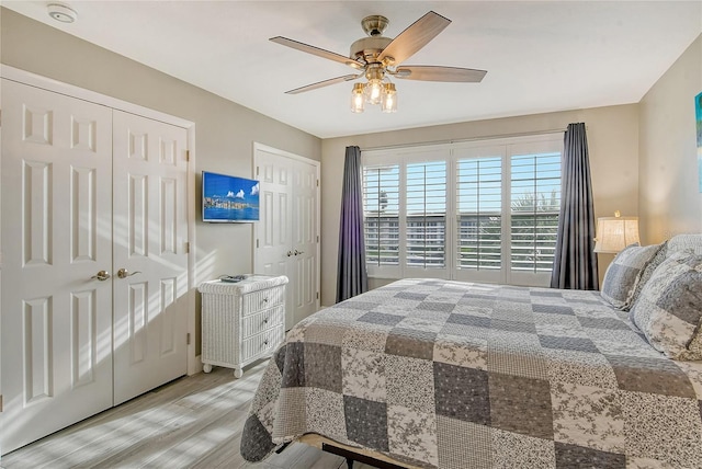 bedroom with multiple closets, ceiling fan, and light hardwood / wood-style flooring