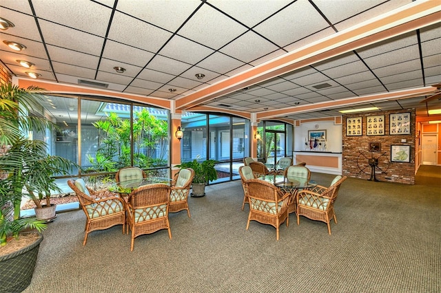 sunroom featuring a drop ceiling and a wealth of natural light