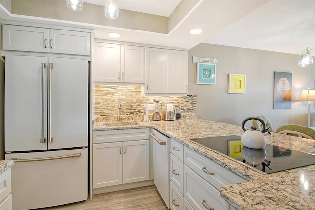 kitchen featuring sink, white appliances, white cabinets, and backsplash