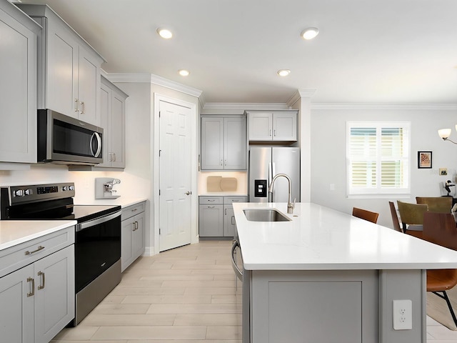 kitchen featuring a kitchen breakfast bar, gray cabinetry, and stainless steel appliances