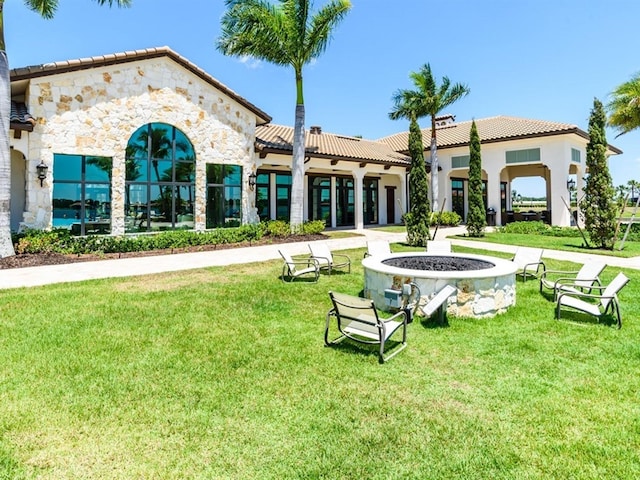 view of home's community with a lawn and a fire pit