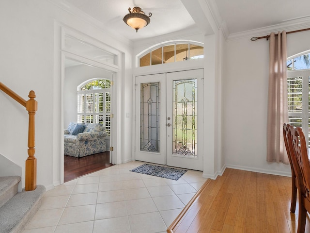 tiled foyer with french doors and ornamental molding