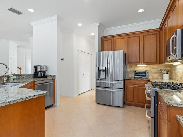 kitchen featuring appliances with stainless steel finishes, light tile patterned floors, light stone counters, and sink