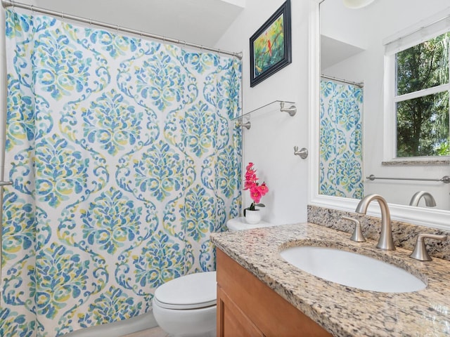 bathroom featuring a shower with curtain, vanity, and toilet