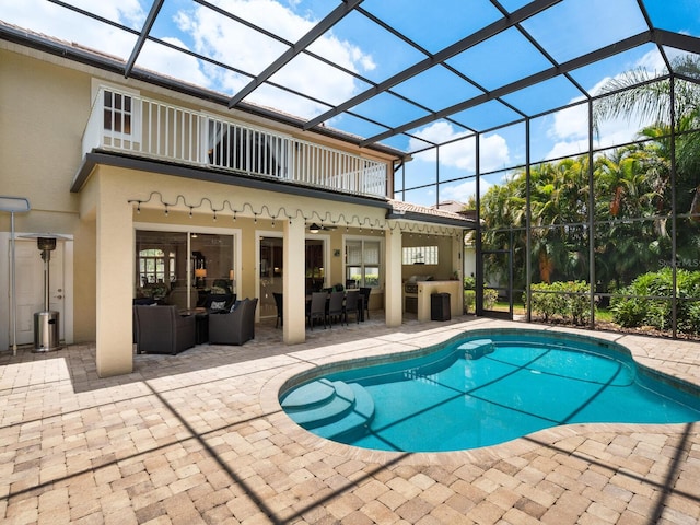 view of swimming pool featuring outdoor lounge area, glass enclosure, and a patio area