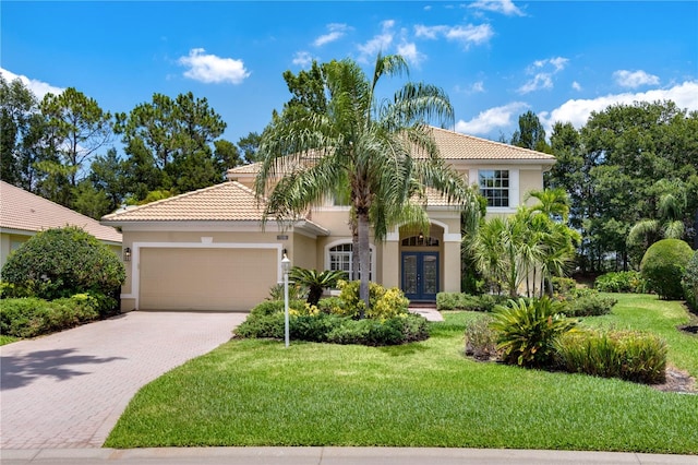 mediterranean / spanish-style home with a front yard, french doors, and a garage