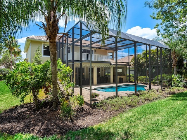 back of house with a yard, a patio, and glass enclosure