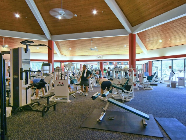 gym featuring carpet, a wealth of natural light, wooden ceiling, and ceiling fan