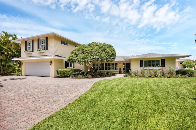 view of front of home with a front yard and a garage