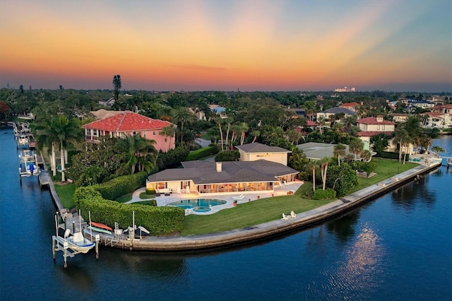 aerial view at dusk featuring a water view