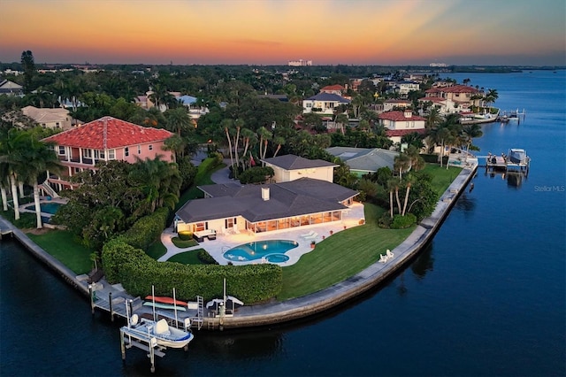 aerial view at dusk featuring a water view