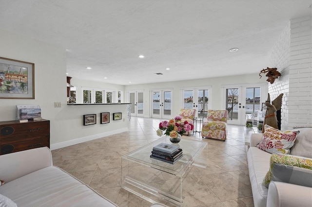 living room featuring a textured ceiling, light tile patterned floors, a fireplace, and french doors