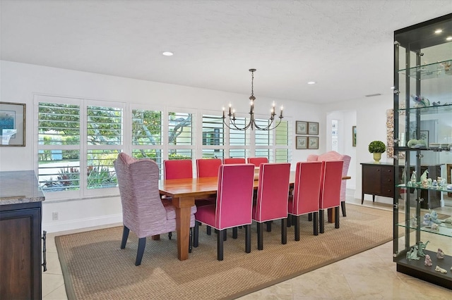 dining space with light tile patterned floors, an inviting chandelier, and a textured ceiling