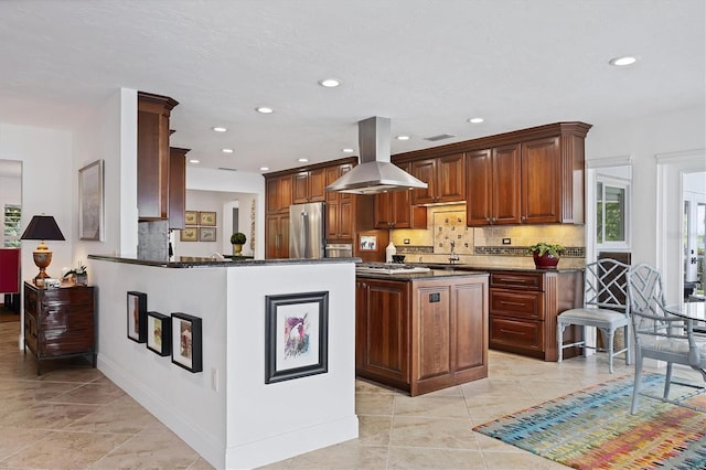 kitchen with a center island, tasteful backsplash, stainless steel fridge, kitchen peninsula, and island range hood