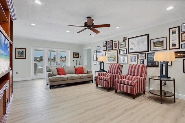 living room with ceiling fan, light wood-type flooring, and crown molding