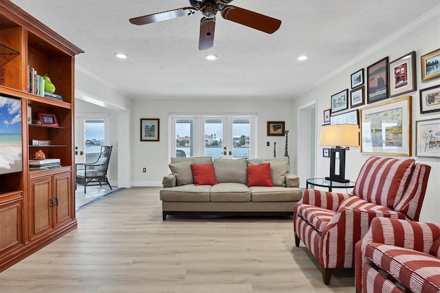 living room featuring light hardwood / wood-style floors, ceiling fan, french doors, a textured ceiling, and crown molding