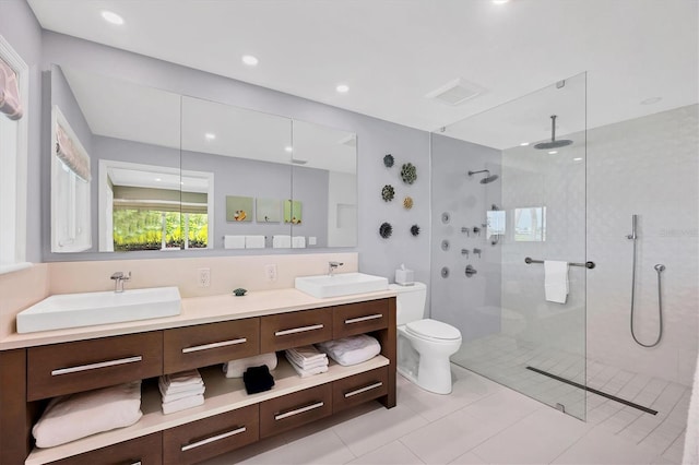 bathroom with toilet, a tile shower, tile patterned floors, and vanity