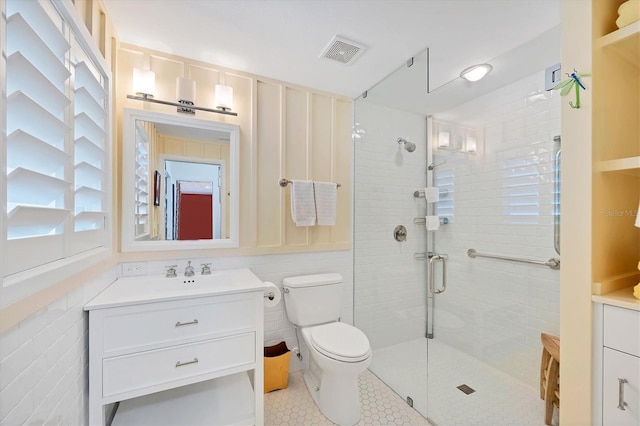 bathroom featuring toilet, tile patterned floors, a shower with shower door, and vanity