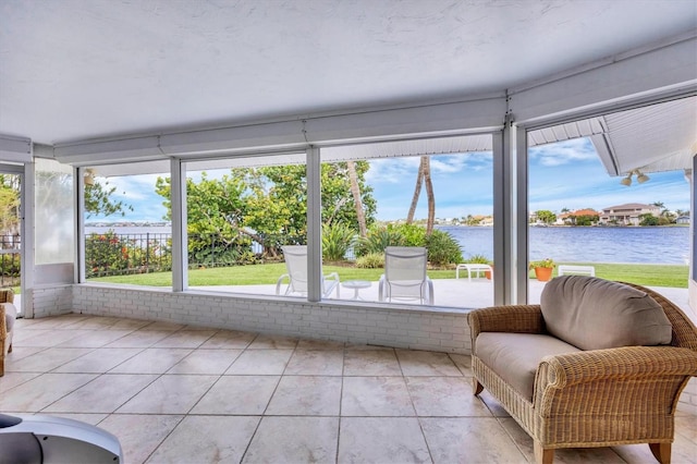 sunroom featuring a water view