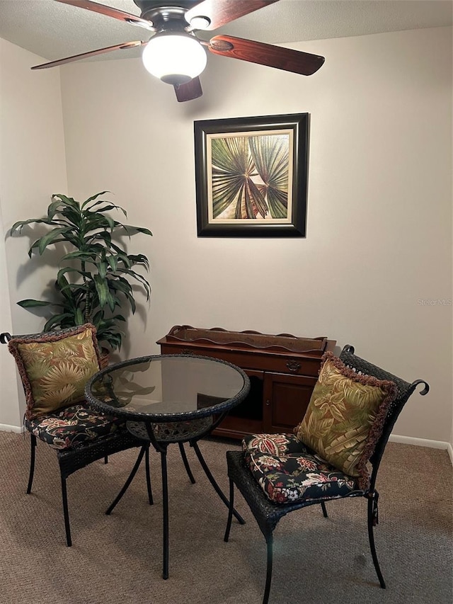 sitting room with carpet floors, baseboards, and a ceiling fan